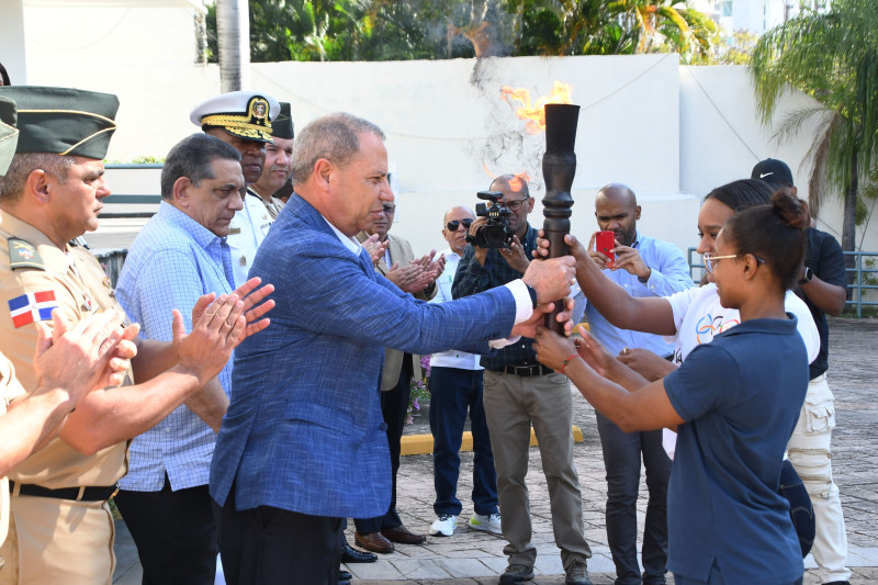 El presidente del COD, ingeniero Garibaldy Bautista, recibe la antorcha de manos de las deportistas Yuderkis Contreras y Beatriz Pirón.