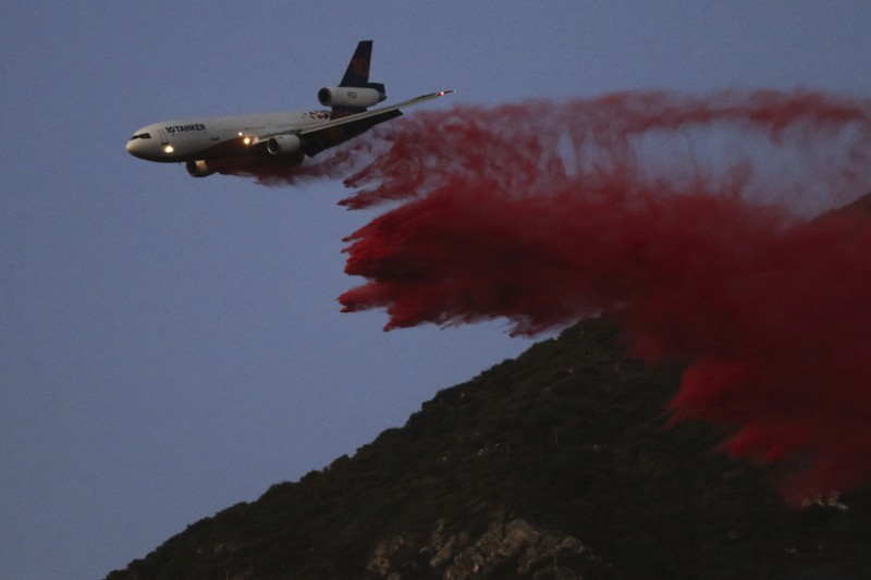 Un avión cisterna arroja retardante mientras combate el incendio de Eaton