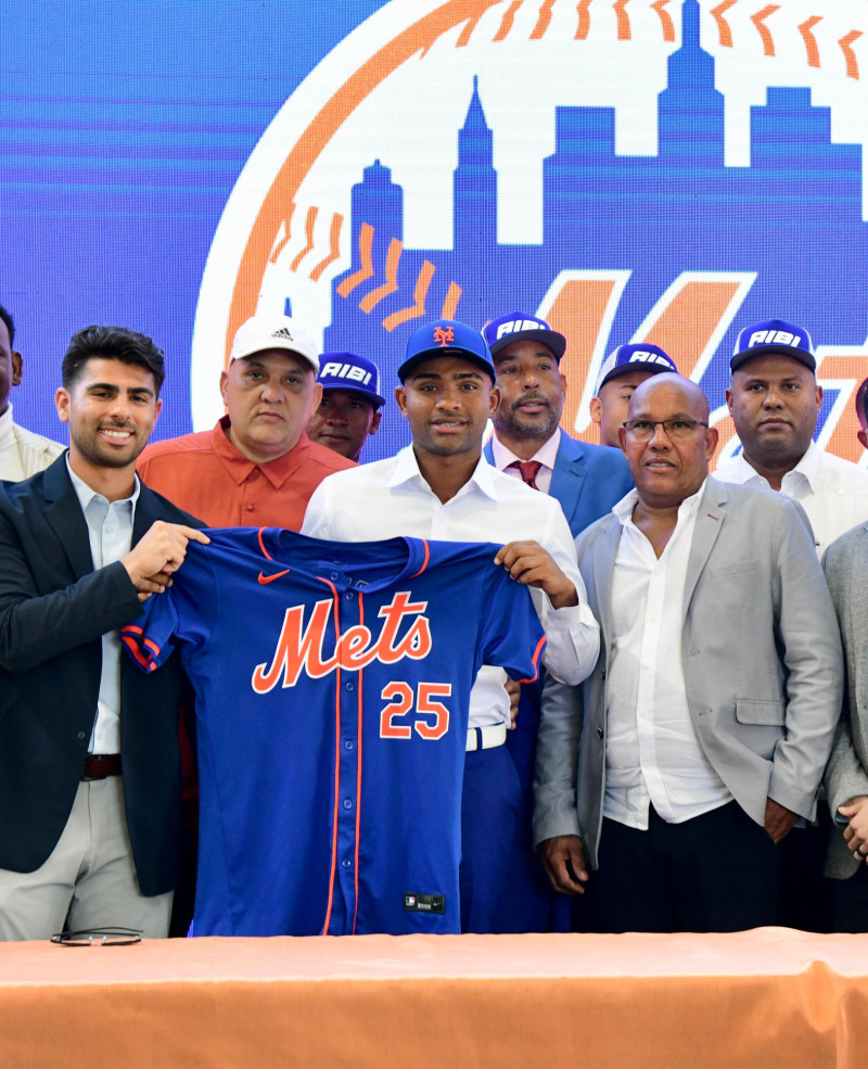 Elian Peña exhibe la camiseta de los Mets, minutos después de estampar su firma de 5 millones. Figuran el padre del novato, así como sus entrenadores Javier Rodríguez y Carlos Hernandez