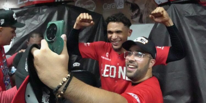 El lesionado torpedero Erik González comparte un selfie con un fanático del Escogido en medio de la celebración.