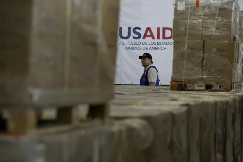Un hombre pasa frente a cajas de ayuda humanitaria de USAID en un almacén en las afueras de Cúcuta, Colombia, el 21 de febrero de 2019, en la frontera con Venezuela. (AP Foto/Fernando Vergara)