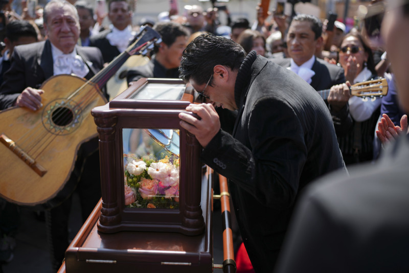 Un amigo en duelo con la cabeza apoyada sobre la urna que contiene los restos de Paquita la del Barrio en un homenaje póstumo en la plaza Garibaldi, en Ciudad de México, el viernes 21 de febrero de 2025