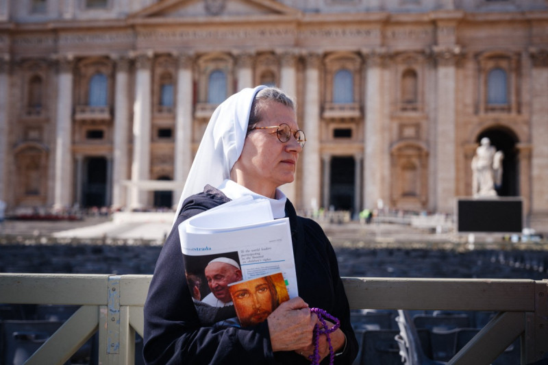 Una monja camina con el periódico "Osservatore Romano" bajo el brazo mientras el Papa Francisco todavía está hospitalizado con neumonía y no dirigirá la oración del Ángelus, en la plaza de San Pedro en el Vaticano el 2 de marzo de 2025.