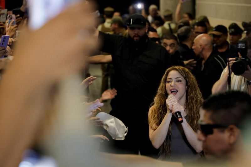 La estrella pop colombiana Shakira canta para sus fans afuera de un hotel