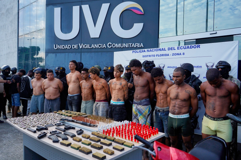 Detenidos esposados son mostrados a la prensa después de su arresto.