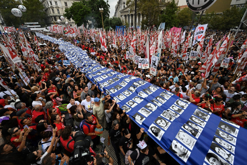 Manifestantes portan una gran pancarta con retratos de desaparecidos durante la dictadura militar (1976-1983)rumbo a la Plaza de Mayo, ayer.