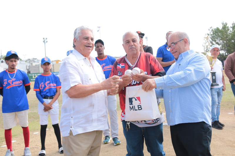 Chilote Llenas entrega pelotas a los directivos de la Liga Deportiva Serrana para el torneo de béisbol.