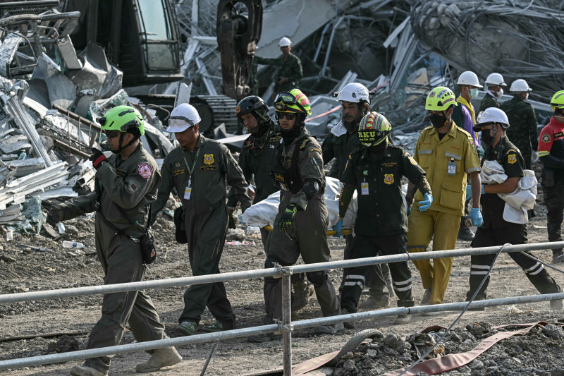 Rescatistas cargan el cuerpo de una víctima en el lugar del derrumbe de un edificio en construcción en Bangkok el 29 de marzo de 2025, un día después de que un terremoto azotara el centro de Myanmar y Tailandia.