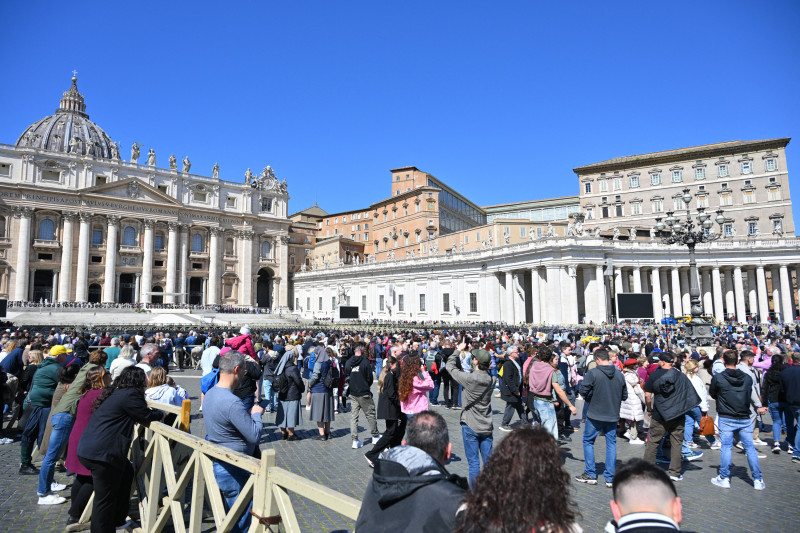 La gente se reúne en la Plaza de San Pedro mientras el Papa no está disponible por enfermedad y no dirigirá el rezo del Ángelus en el Vaticano el 30 de marzo de 2025. (Foto de Andreas SOLARO