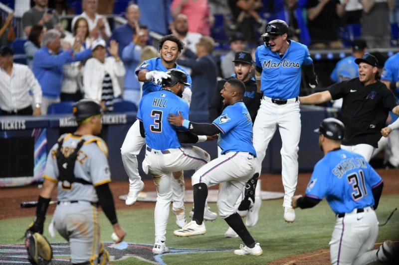Jugadores de los Marlins de Miami celebran después de que Derek Hill (3) anotara la carrera de la victoria frente a los Piratas de Pittsburgh el domingo 30 de marzo de 2025.