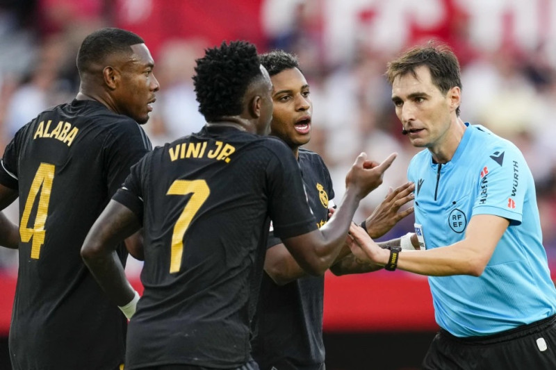 El árbitro Ricardo De Burgos Bengoetxea (derecha) discute con jugadores del Real Madrid durante el partido contra Sevilla en la Liga española, el 21 de octubre de 2023.
