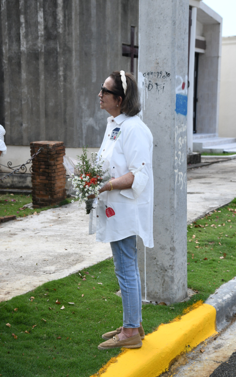 Tania Férnandez sosteniendo las flores para la tumba de su madre.