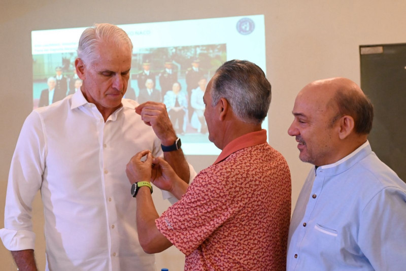 Miguel Then, second vice president of the Naco Club, presents the award to Aldo Leschhorn.