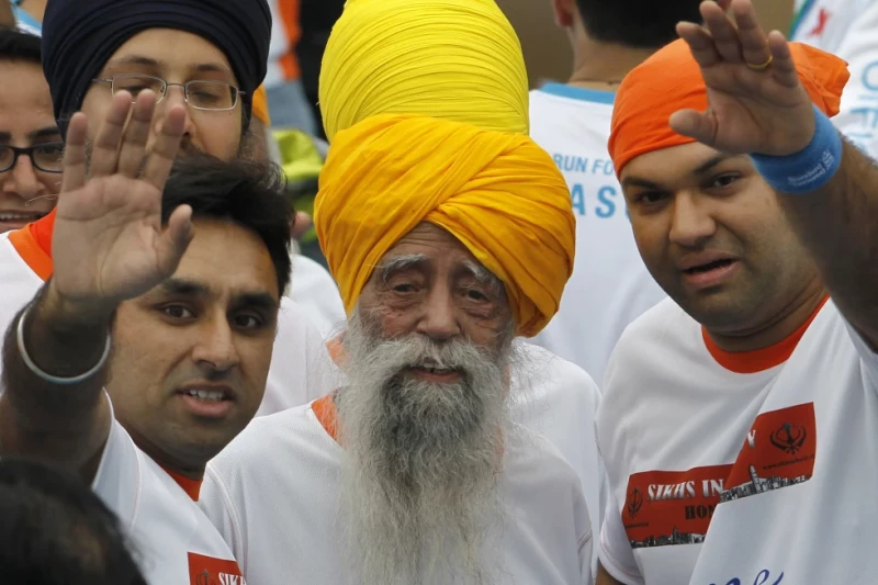 El centenario maratonista Fauja Singh sonríe tras completar una carrera de 10 kilómetros como parte del maratón de Hong Kong, el 24 de febrero de 2013.