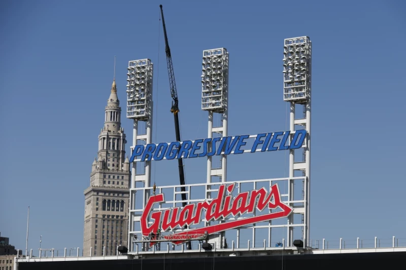 Los obreros instalan el letrero de los Guardianes de Cleveland en el estadio Progressive Field, el 17 de marzo de 2022, en Cleveland.