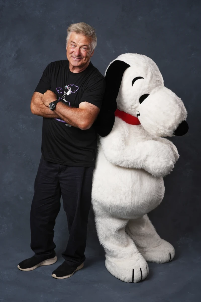 Alec Baldwin, a la izquierda, y una persona vestida como el personaje Snoopy de "Peanuts" posa para un retrato para promocionar el 75 aniversario de "Peanuts" durante Comic-Con International el jueves 24 de julio de 2025 en San Diego. (AP Photo/Chris Pizzello)