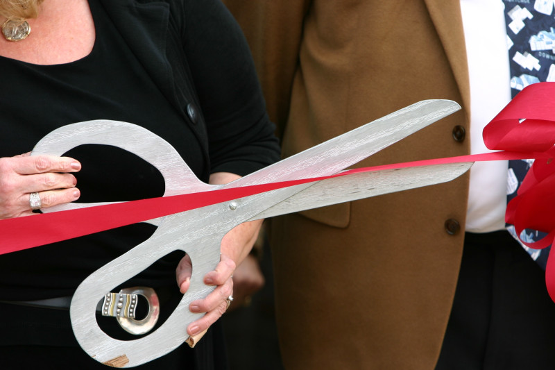 Tijeras ceremoniales. Grandes, metálicas, decorativas. Presentadas en una bandeja o cojín con tela noble.