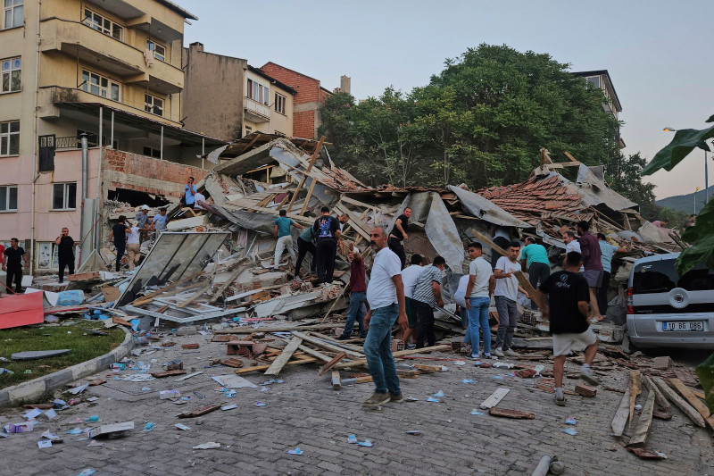 Personas retiran los escombros de un edificio derrumbado tras un terremoto en Sindirgi, noroeste de Turquía, ayer domingo.
