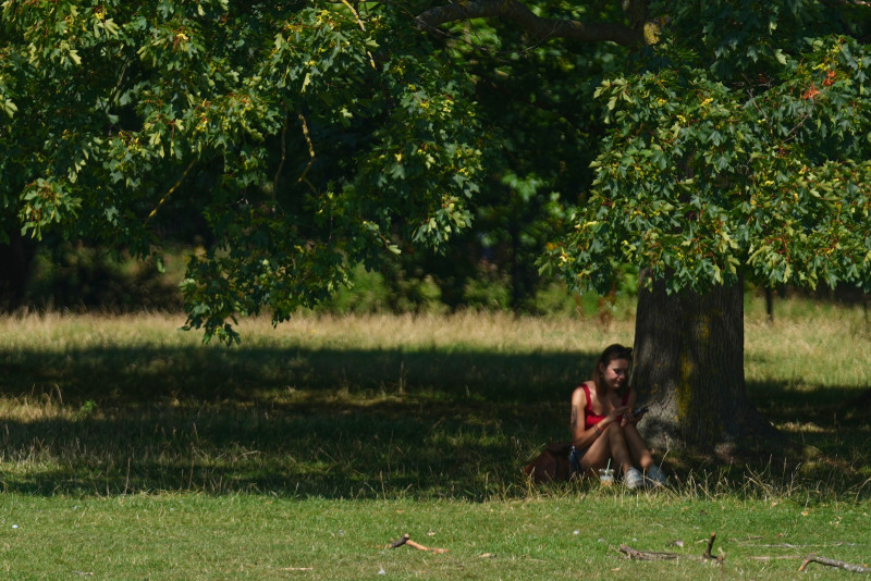 Una persona se resguarda del sol en Londres mientras partes del Reino Unido y el resto de Europa enfrentan una ola de calor, ayer lunes.