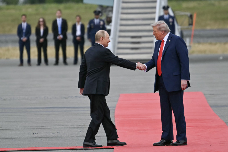 El presidente estadounidense Donald Trump (der.) saluda al presidente ruso Vladimir Putin en la pista tras su llegada a la Base Conjunta Elmendorf-Richardson en Anchorage, Alaska, el 15 de agosto de 2025.
