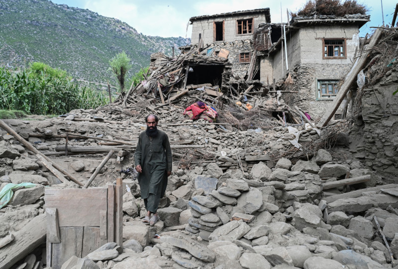 Un hombre afgano pasa junto a una casa dañada tras los terremotos en la aldea de Mazar Dara, en Nurgal, distrito de la provincia de Kunar, en el este de Afganistán, el 1 de septiembre de 2025. Más de 800 personas murieron y más de 2700 resultaron heridas desde la noche del 31 de agosto hasta el 1 de septiembre de 2025 en el este de Afganistán tras un terremoto de magnitud 6, seguido de al menos cinco réplicas que se sintieron a cientos de kilómetros de distancia. (Foto de Wakil Kohsar / AFP)