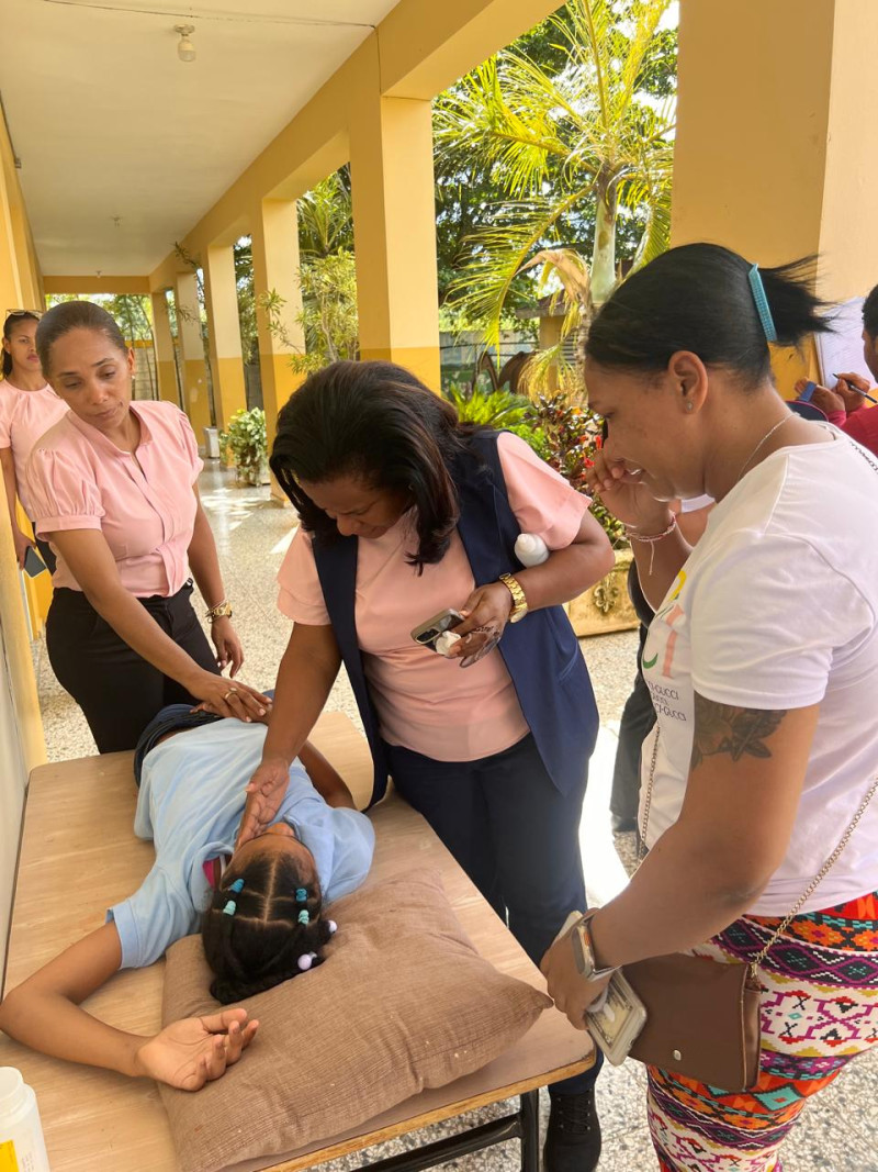 Profesoras asisten a una de las estudiantes afectadas por intoxicación en San Francisco de Macorís.