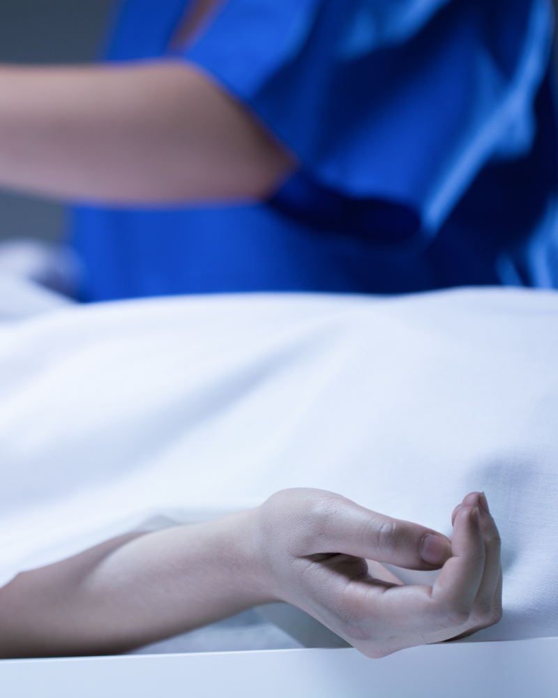 Imagen ilustra a un forense estudiando un cadáver en la morgue.