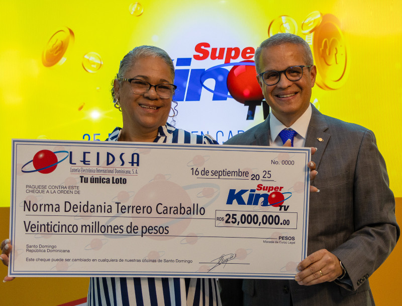 La señora Norma Deidania Terrero Caraballo recibe su cheque de 25 millones de pesos.