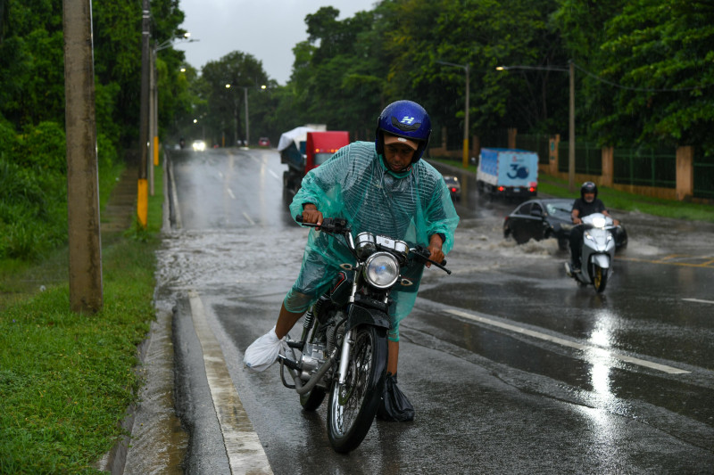 Un motorista enfrenta inconvenientes para hacer andar su motocicleta en la avenida Ecológica profesor Juan Bosch, en Santo Domingo Norte
