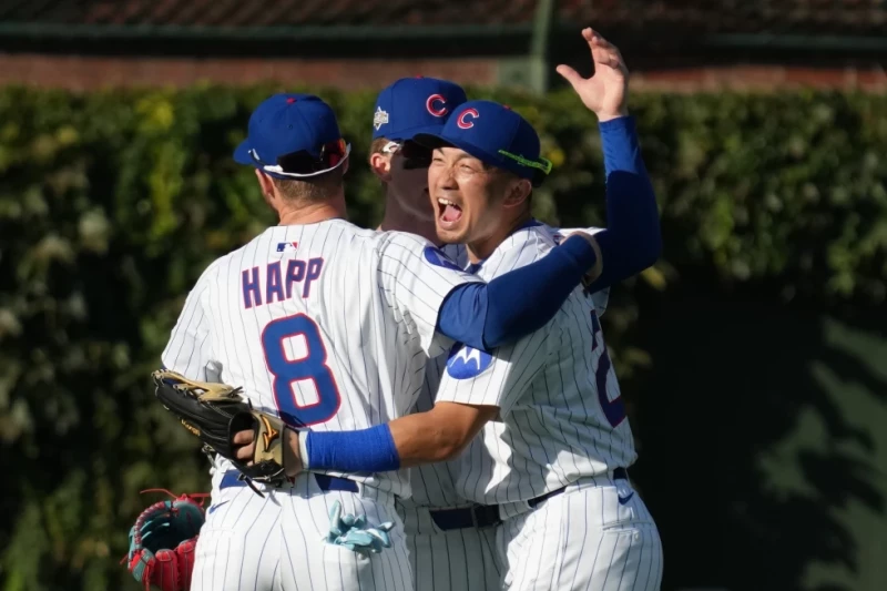 Seiya Suzuki, Pete Crow-Armstrong e Ian Happ se abrazan para celebrar el triunfo de los Cachorros en el juego 1 de la serie de comodín ante los Padres.