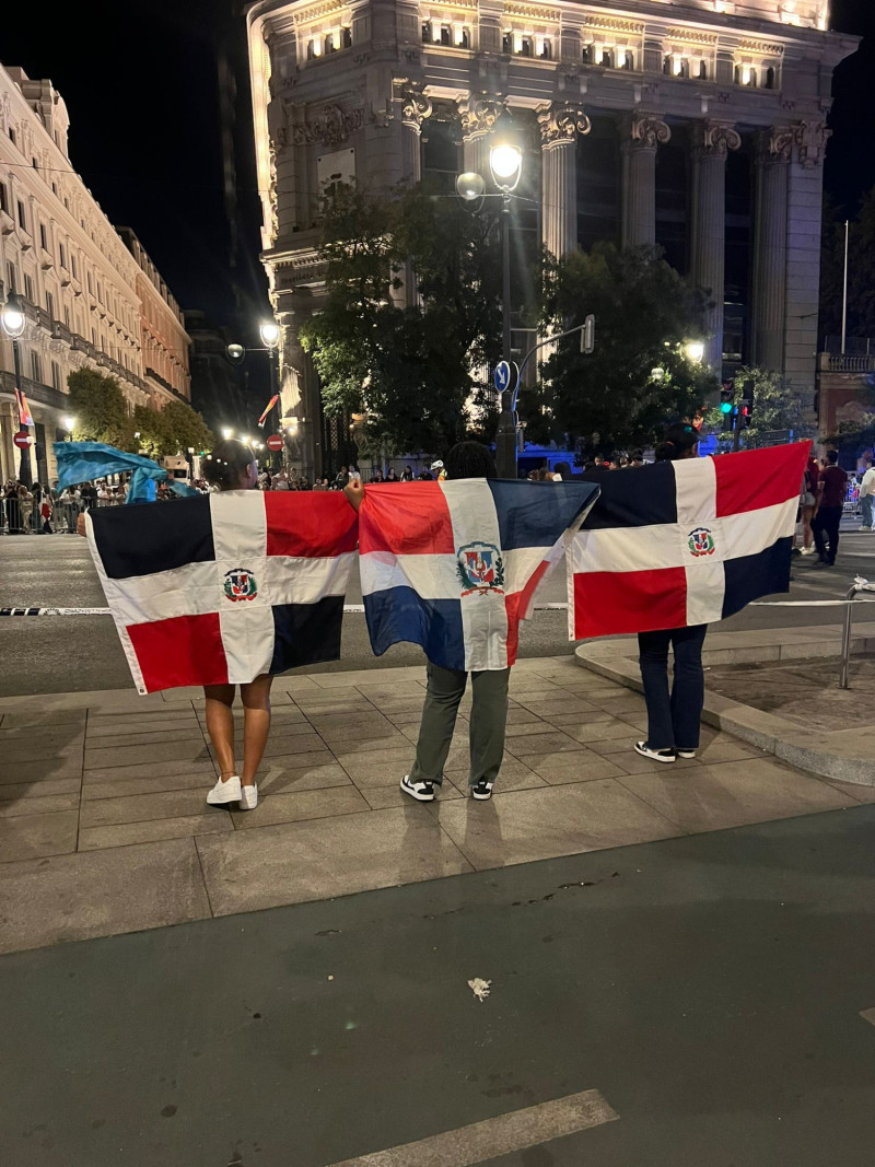 Dominicanos exhiben la bandera nacional durante la Cabalgata de la Hispanidad celebrada este domingo en Madrid.