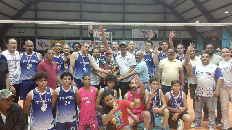 El acomodador y capitán de Tamboril, Edward Rojas, recibe la copa de campeón masculino de manos de Francisco Leoni  Fernández, el alcalde de Licey al Medio, Domingo Almonte,  y José –Yeye—Aybar .