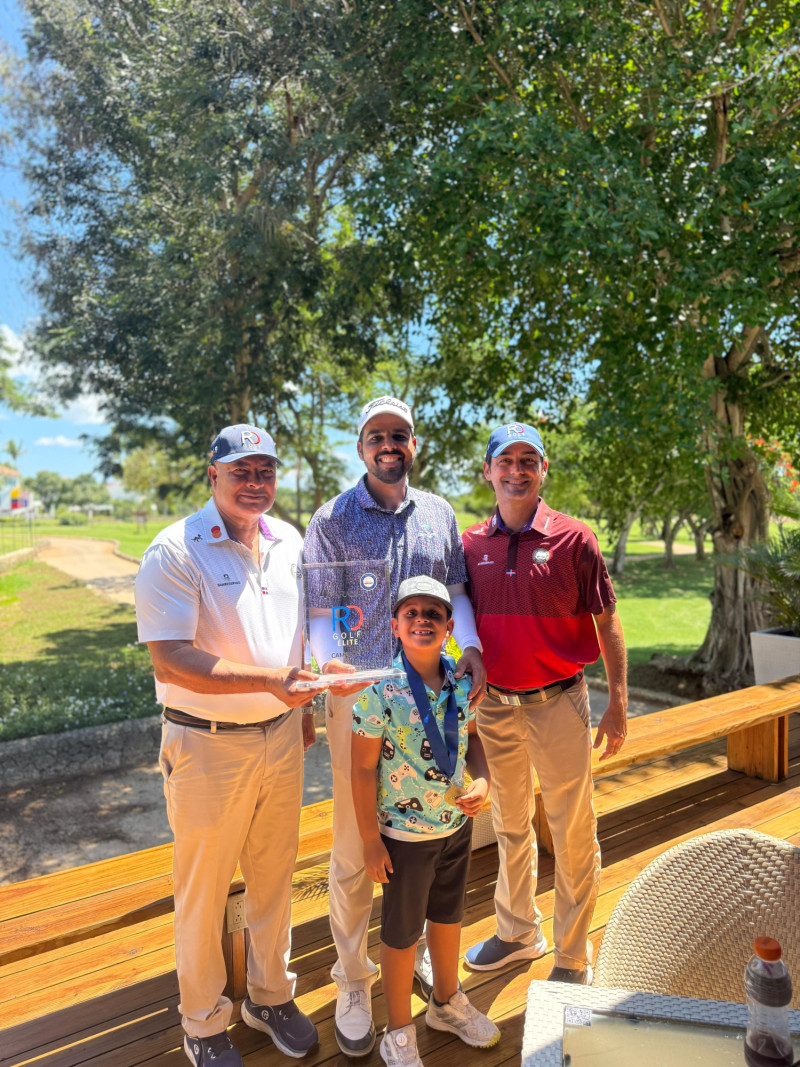 Luis José Placeres y Andrea Attus entregan el trofeo al campeón Rhadamés Peña. Figura un niño en la premiación.