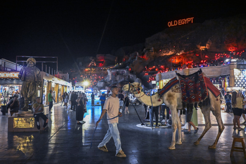 Un camellero espera a los turistas en la zona comercial de Sharm el-Sheij, un balneario egipcio en el Mar Rojo, el 9 de octubre de 2025, donde las facciones israelíes y palestinas acordaron previamente un alto el fuego en Gaza.