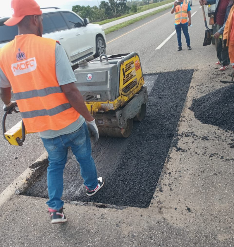 Brigada del Ministerio de Obras Públicas cubriendo hoyos en la autopista Duarte.