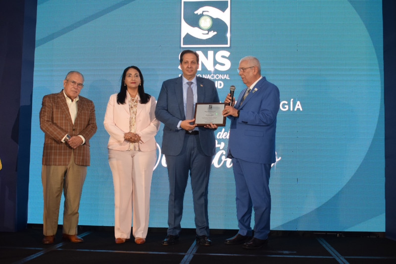 Víctor Atallah, ministro de Salud recibe su reconocimiento de los doctores Luis Feris Iglesias, Lia Diaz y Mario Bournigal.