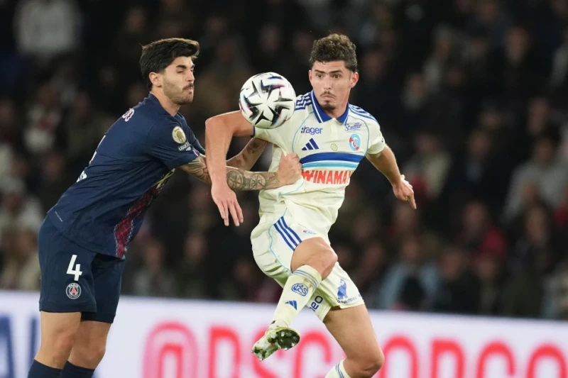 Lucas Beraldo, izquierda, del PSG, y Joaquin Panichelli, del Estrasburgo, disputan un balón durante el partido de fútbol de la Ligue 1 de Francia, el 17 de octubre de 2025.