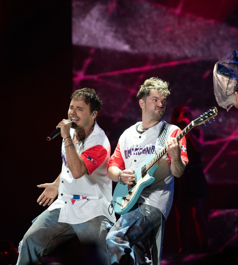 Benjamín Rojas y Felipe Colombo luciendo camiseta de la selección dominicana de béisbol durante el concierto de Erreway en Santo Domingo.