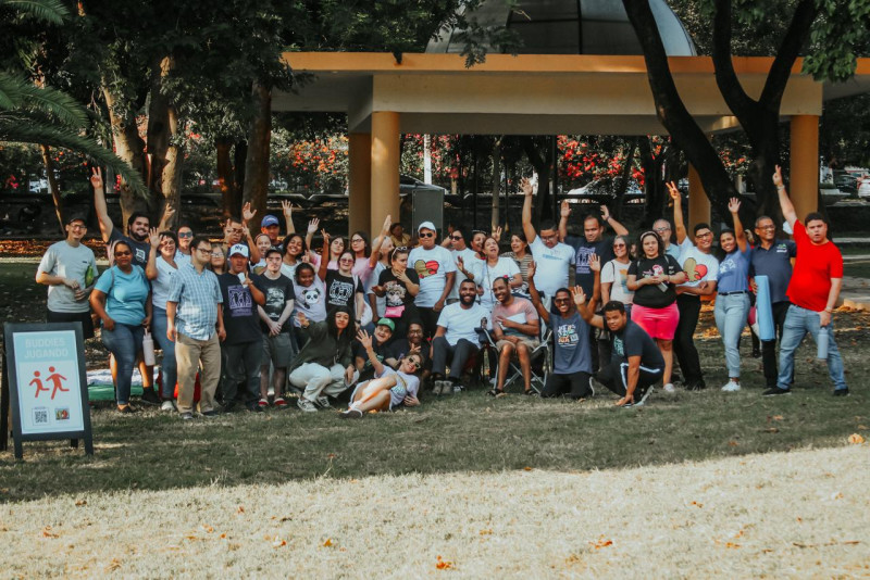 Staff voluntario junto a buddies en un evento social en un parque