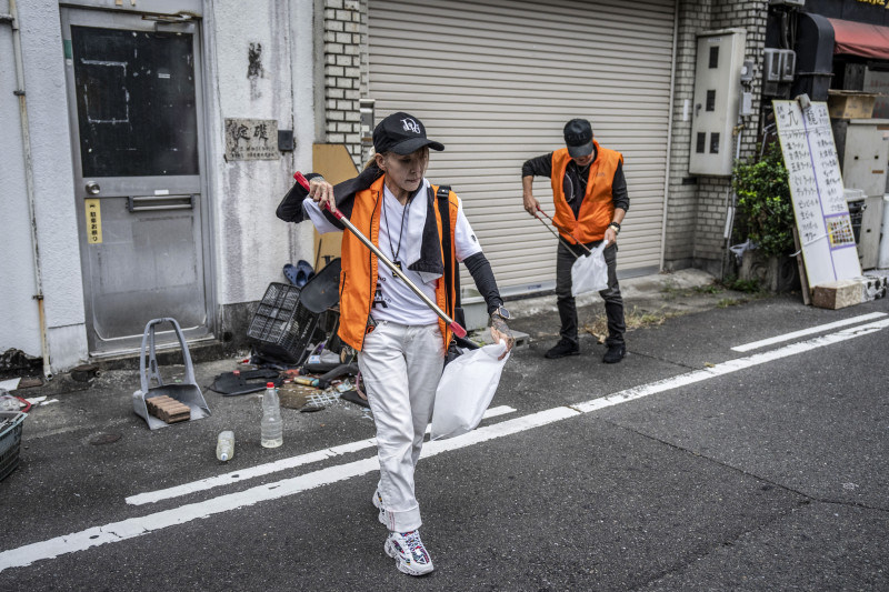 En esta fotografía tomada el 28 de septiembre de 2025, la yakuza retirado Mako Nishimura (izquierda) recoge residuos desechados junto con exdelincuentes como parte de su actividad mensual en Gifu