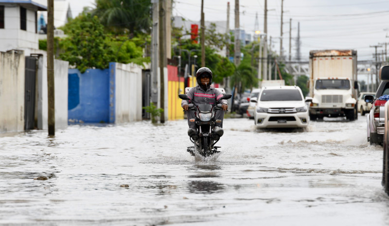 Motorista desplazándose pese a las inundaciones en El Almirante.