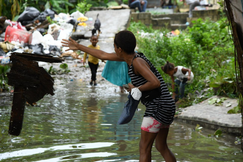 Una mujer lanza un pedazo de madera en el río