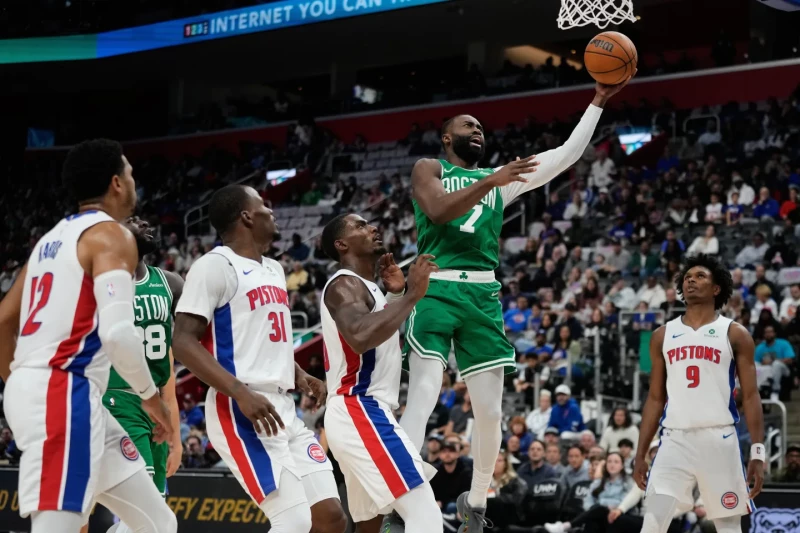 Jaylen Brown, de los Celtics, se eleva en busca de un canasto ante la mirada de varios jugadores de los Pistons en el partido del domingo de la NBA.