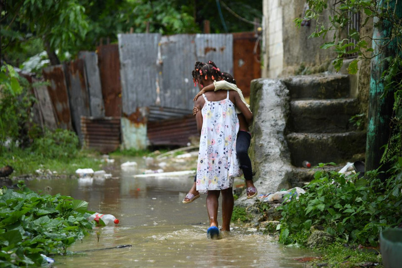 Una niña carga a otra en  El Túnel, de Capotillo, en el Distrito Nacional