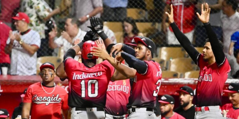 Jugadores de los Leones del Escogido saludan a Sócrates Brito luego de anotar una carrera.