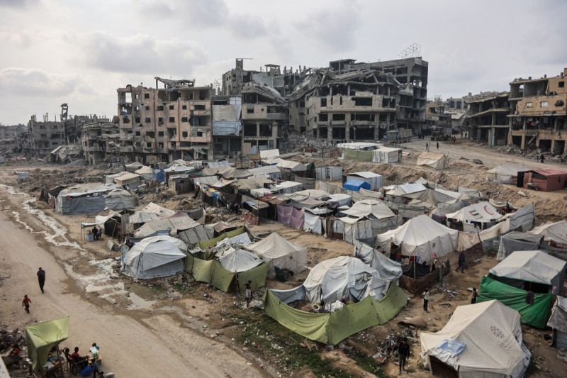 Palestinos caminan alrededor de sus tiendas de campaña en la ciudad de Gaza