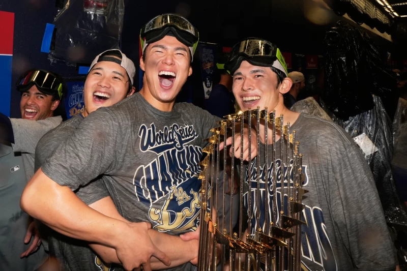 Shohei Ohtani, Yoshinobu Yamamoto y Roki Sasaki, de los Doegers, celebran la victoria ante los Azulejos en el séptimo juego de la Serie Mundial.