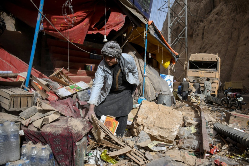 Un comerciante afgano busca restos humanos frente a su tienda dañada en una carretera tras el terremoto que sacudió Tang-e Tashqurghan, en el distrito de Khulm, provincia de Samangan.