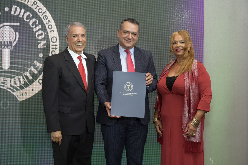 Román Jáquez, presidente de la Junta Central Electoral, al recibir su reconocimiento. Le entregan Carlos Cepeda Suriel y Marisol Pérez viuda Rivera.