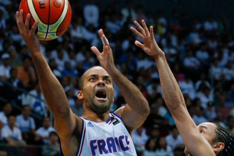 Tony Parker lanza el balón sobre Jeff Chan de Filipinas durante el juego de baloncesto de clasificación olímpica de la FIBA del Grupo B, el martes 5 de julio de 2016, en la ciudad suburbana de Pasay, al sur de Manila, Filipinas.